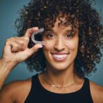 woman holding clear aligners for clear aligner faqs