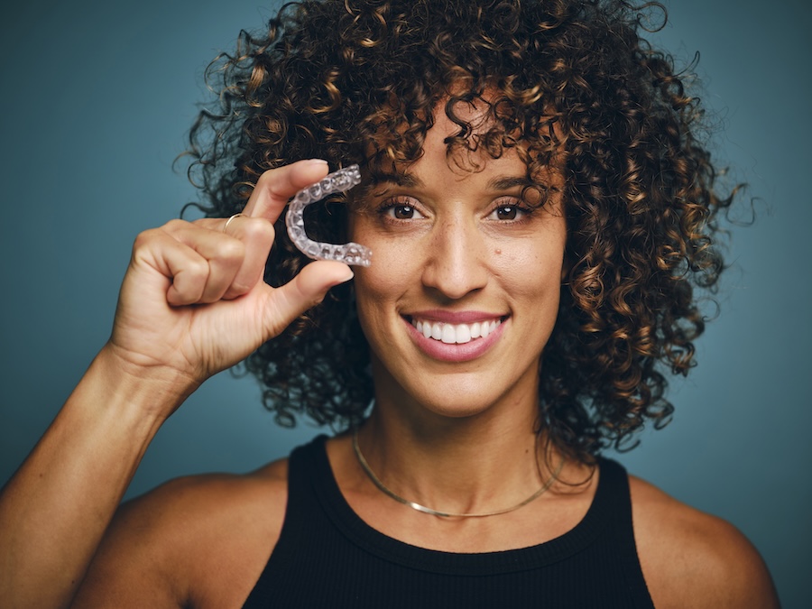 woman holding clear aligners for clear aligner faqs